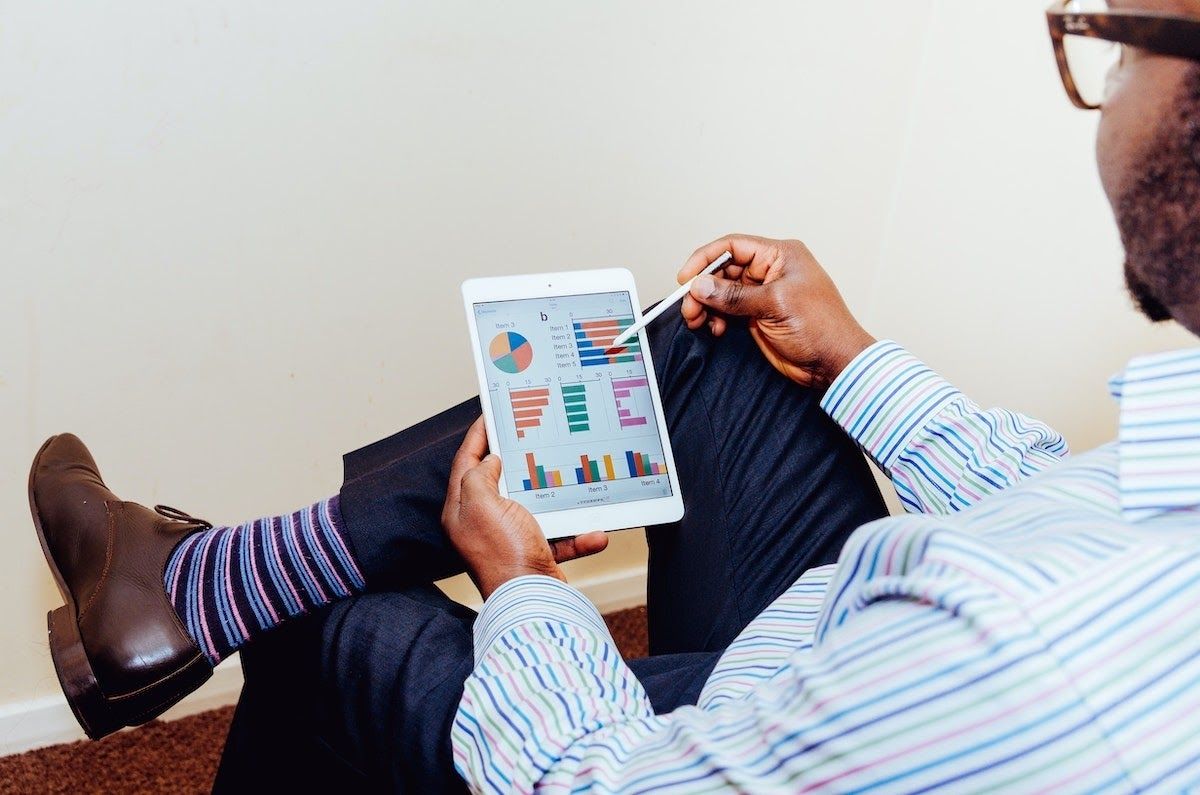 Person sitting with a tablet viewing a data visualization platform.