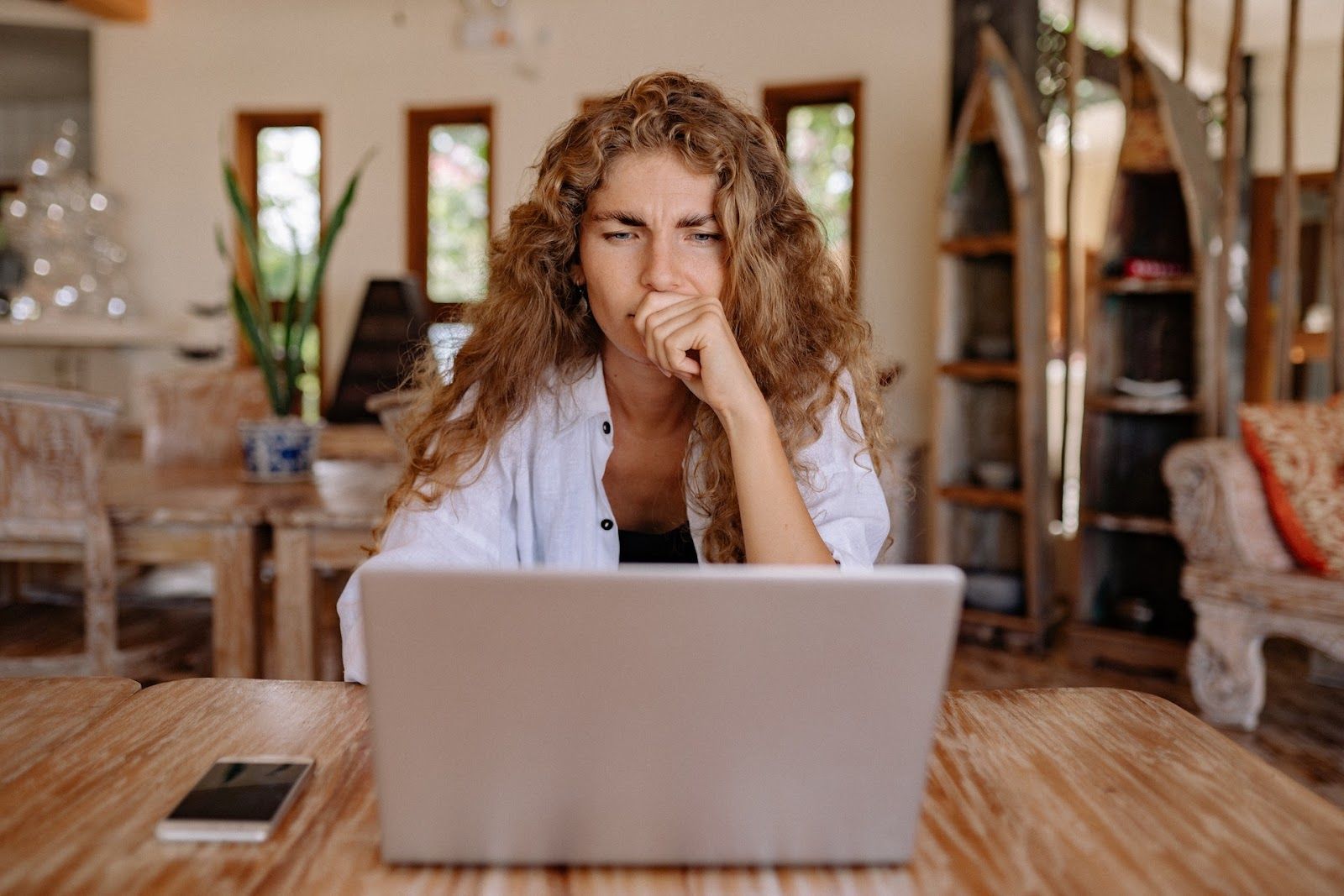 Person sitting at a table with a laptop comparing Qualtrics competitors.